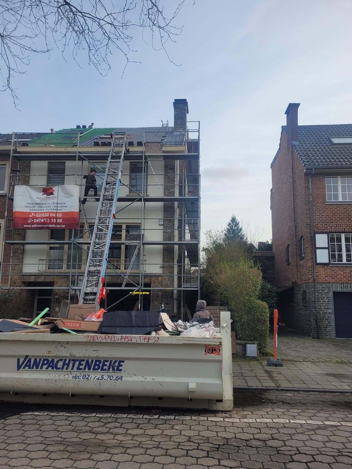 Street-side roof renovation with facade scaffolding
