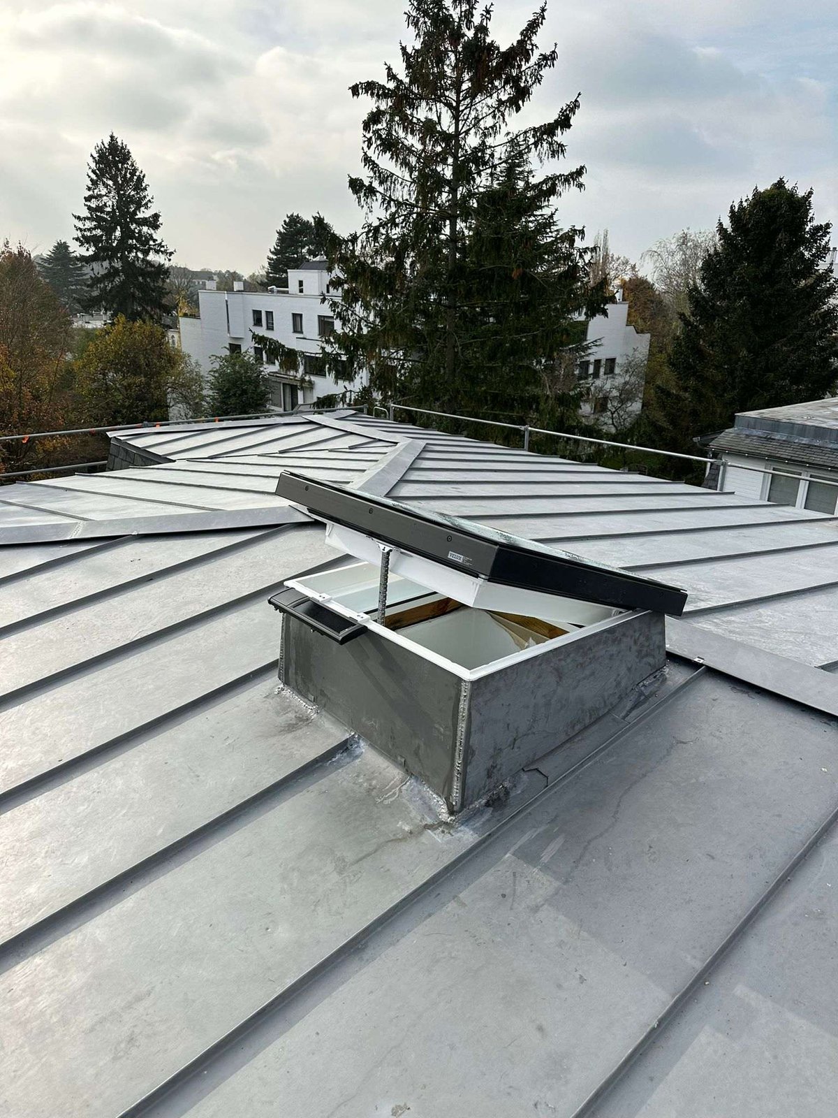 Standing-seam zinc roof with an open roof window